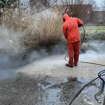 Straatwerk reinigen rondom parkeerplaatsen hoofkantoor zorginstelling Hoorn December 2022